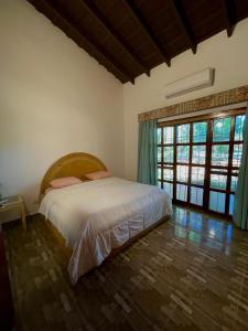 a bedroom with a bed and a large window at Casa de Campo Las Marías in Areguá