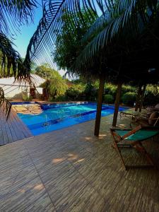 a chair and an umbrella next to a swimming pool at Casa de Campo Las Marías in Areguá