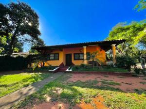 a small yellow house with a driveway at Casa de Campo Las Marías in Areguá