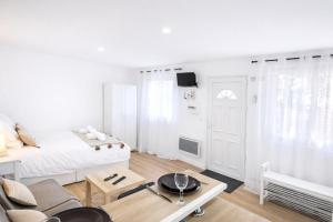 a white bedroom with a bed and a coffee table at 5 Mins to Train Station - Paris & DisneyLand - Cosy des Reves Villiers in Villiers-sur-Marne