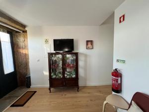 a living room with a cabinet with a television on it at Casa das Romãs in Torre de Moncorvo