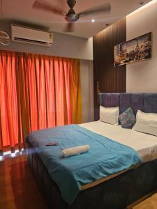 a bedroom with a bed with a blue blanket at Galaxy Blue sapphire Plaza Square Residency in Ghaziabad