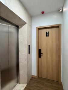 a elevator with a wooden door in a room at Maison du nook in Hanoi