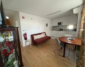 a living room with a table and a kitchen at Casa das Romãs in Torre de Moncorvo