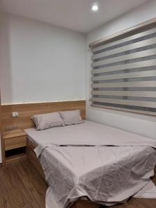 a bedroom with a large bed with a window at Maison du nook in Hanoi