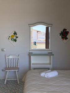 a bedroom with a bed and a chair and a window at Hotel Residence Mendolita in Lipari