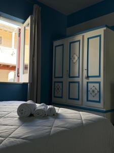 a bedroom with blue walls and a bed with towels at Hotel Residence Mendolita in Lipari