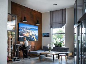 a man sitting at a table in a living room at ibis styles Grudziadz in Grudziądz
