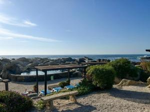 a picnic table and benches on the beach at Departamentos Océano in Maitencillo