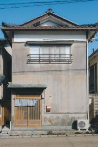 a building with a window and a door at ゲストハウス レトロマチカ in Sakai