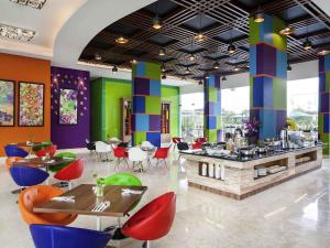 a restaurant with colorful walls and tables and chairs at ibis Styles Cikarang in Cikarang