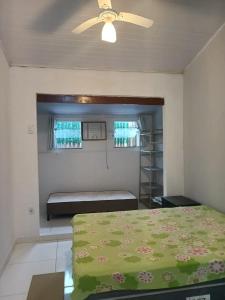 a bedroom with a bed and a ceiling fan at Casa inteira 4 pessoas, 2 quartos, suite ar, 2 banheiros, home office, estacionamento, próx praia Itaúna in Saquarema