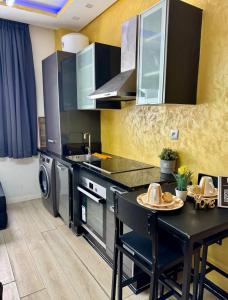 a kitchen with a black counter and a table at Studio pas cher au parc in Mohammedia