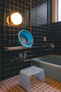 a bathroom with a blue tub and a blue sink at ゲストハウス レトロマチカ in Sakai +13 photos