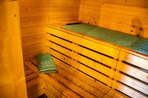 an inside of a wooden sauna with a green towel at miki Chalets in Pack