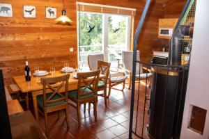 a dining room with a table and chairs and a stove at miki Chalets in Pack