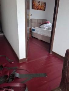 a room with a red floor with a bed and a doorway at Hotel Kandy road in Meda-Ela