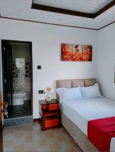 a bedroom with a bed and a bathroom with a tub at Hotel Kandy road in Meda-Ela