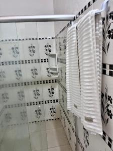 a bathroom with white walls and black and white tiles at Mar de Moreré in Cairu