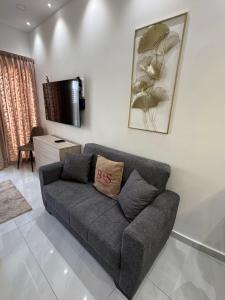 ein Wohnzimmer mit grauem Sofa und einem Fernseher in der Unterkunft B&S Accommodation Unit 252 in Żejtun + 11 Fotos