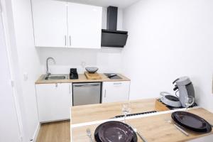 a small kitchen with white cabinets and a sink at 5 Mins to Train Station - Paris & DisneyLand - Cosy des Reves Villiers in Villiers-sur-Marne