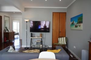 a living room with a couch and a tv on a wall at Sea Breeze Apartment in Lagos