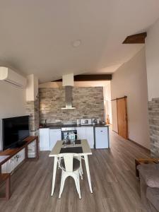 a kitchen and living room with a table and a couch at El niu del volcà in Olot