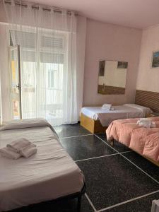 a hotel room with two beds and a window at Hotel & Trattoria Le Caravelle in Lavagna