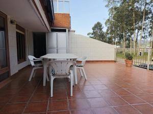 a patio with a table and chairs on a balcony at Nido Ría in Villaviciosa