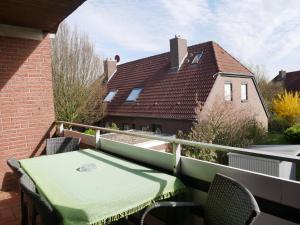 a table and chairs on the balcony of a house at Haus Gertrud in Carolinensiel