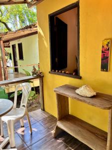 a yellow room with a table and a table and chairs at Mar de Moreré in Cairu