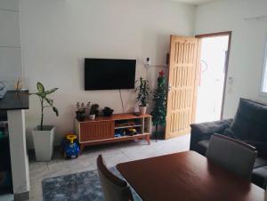 a living room with a flat screen tv on a wall at Condomínio - Dell Mar III in Bertioga