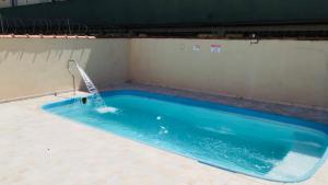 a swimming pool with a water fountain at Condomínio - Dell Mar III in Bertioga +7 photos