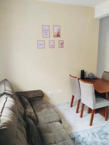 a living room with a couch and a table and chairs at Condomínio - Dell Mar III in Bertioga