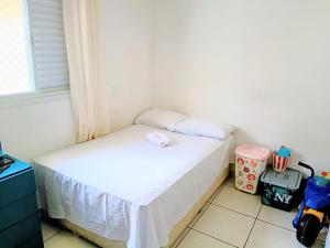a small bed in a room with a window at Condomínio - Dell Mar III in Bertioga