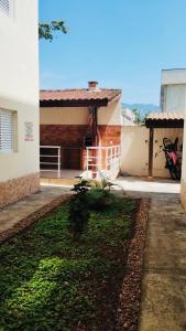 a house with a yard next to a building at Condomínio - Dell Mar III in Bertioga