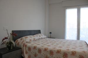 a bedroom with a bed with a blanket and a window at Perla dell'Adriatico in San Benedetto del Tronto +13 photos
