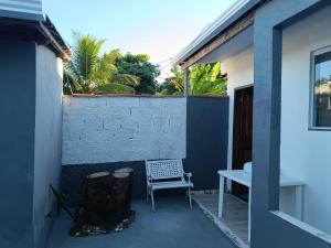a chair sitting on a patio next to a building at Casa inteira 4 pessoas, 2 quartos, suite ar, 2 banheiros, home office, estacionamento, próx praia Itaúna in Saquarema