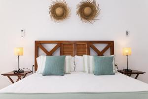 a bedroom with a large white bed with two lamps at Baconer - Casa en l'Ampolla con jardín privado y acceso directo al mar - Deltavacaciones in L'Ampolla