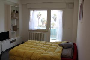 a bedroom with a large yellow bed in front of a window at Perla dell'Adriatico in San Benedetto del Tronto