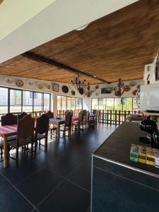 a dining room with tables and chairs and windows at Ribeirinha in Lousã