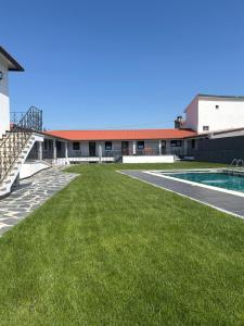 a large yard with a swimming pool and a building at Ribeirinha in Lousã