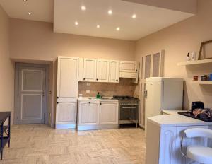 a kitchen with white cabinets and a white refrigerator at L' Appartamento Experience in Tivoli +10 photos