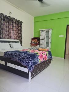 a bedroom with a bed and a green wall at Umashankar Homestay in Nashik +14 photos
