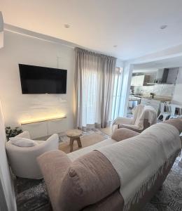 a living room with a couch and chairs and a tv at La Luz in Zuheros