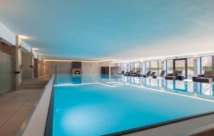 a large pool with blue water in a building at Prince in Binz