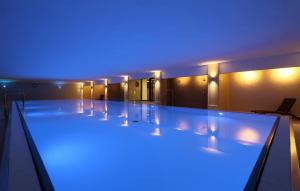 a swimming pool with blue lights in a building at Prince in Binz +35 photos