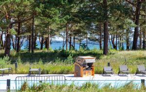 a barbecue grill with chairs and trees in a park at Prince in Binz