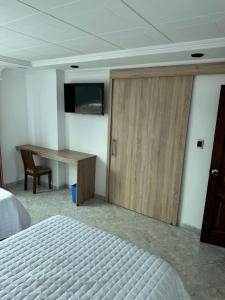 a bedroom with a bed and a desk and a sliding door at Hotel Americas Suites in Bogotá +16 photos