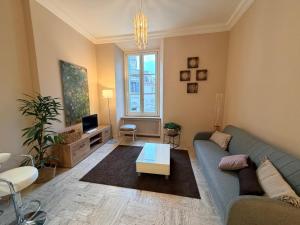 a living room with a blue couch and a table at L' Appartamento Experience in Tivoli